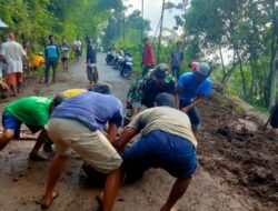 Babinsa Gotong Royong Bersihkan Material Tanah yang Menutup Akses Jalan Penghubung Desa